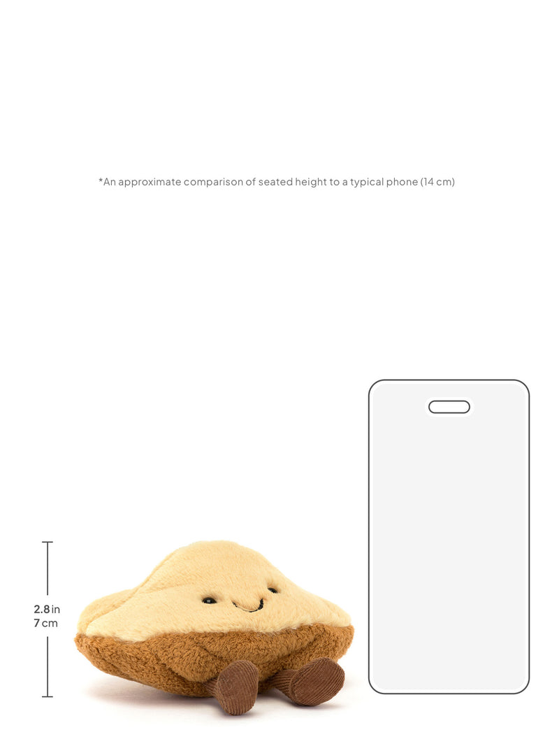 Small pastry-shaped plush toy with dimensions compared to a phone on a white background