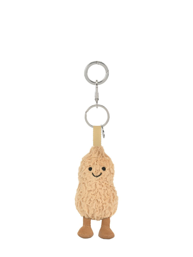 A plush peanut-shaped keychain charm with a smiling face, attached to a beige strap and silver metal key rings, shown on a plain white background.