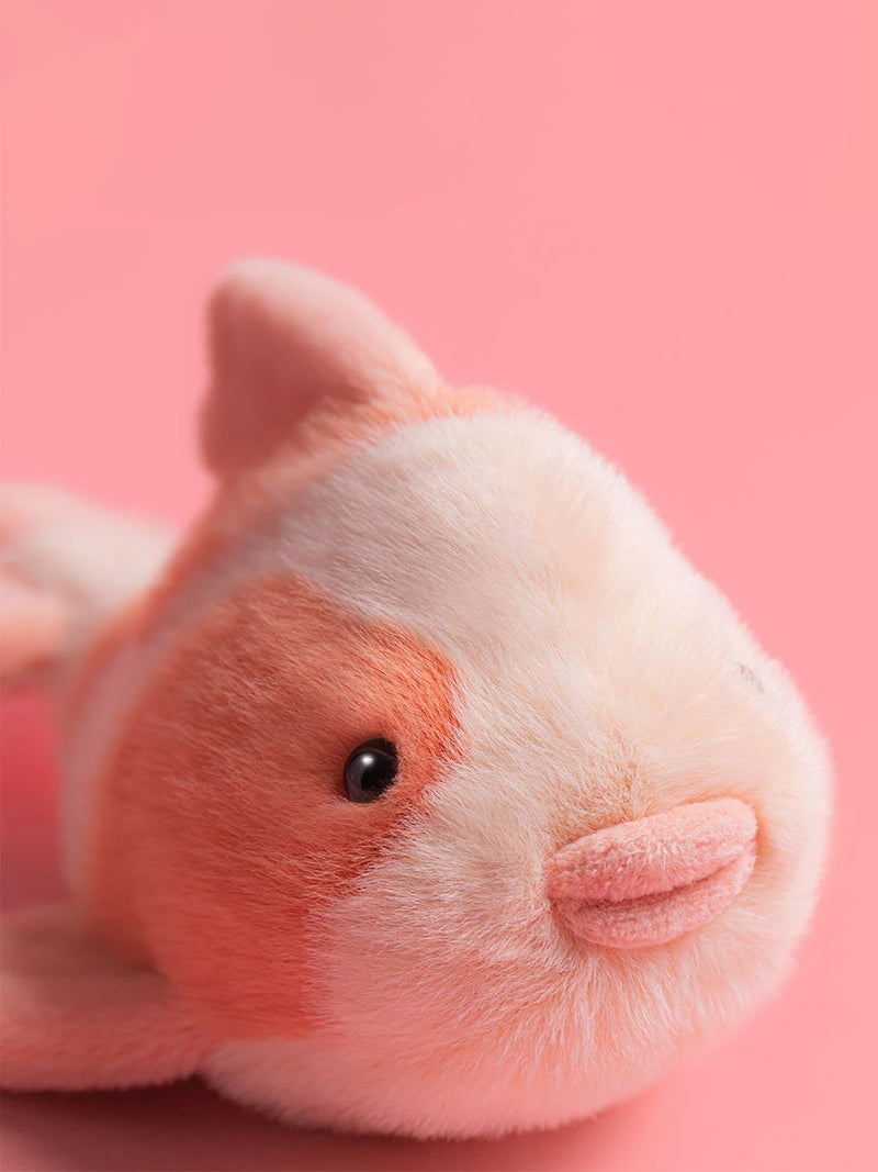 Close-up of a pink and white plush toy on a pink background