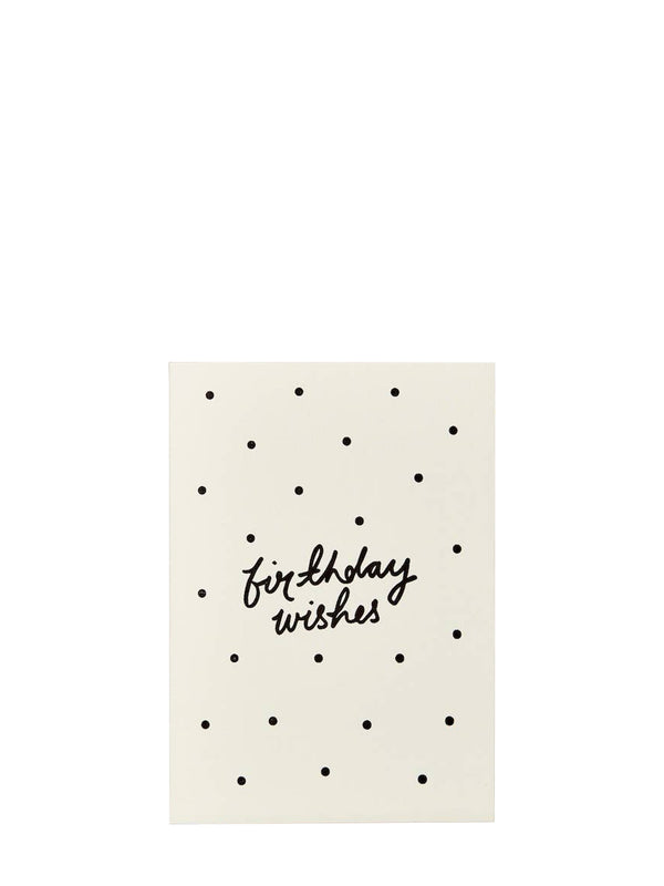 A cream-coloured greeting card with a black polka dot pattern and the words 'birthday wishes' written in black cursive script in the center, shown against a plain white background.