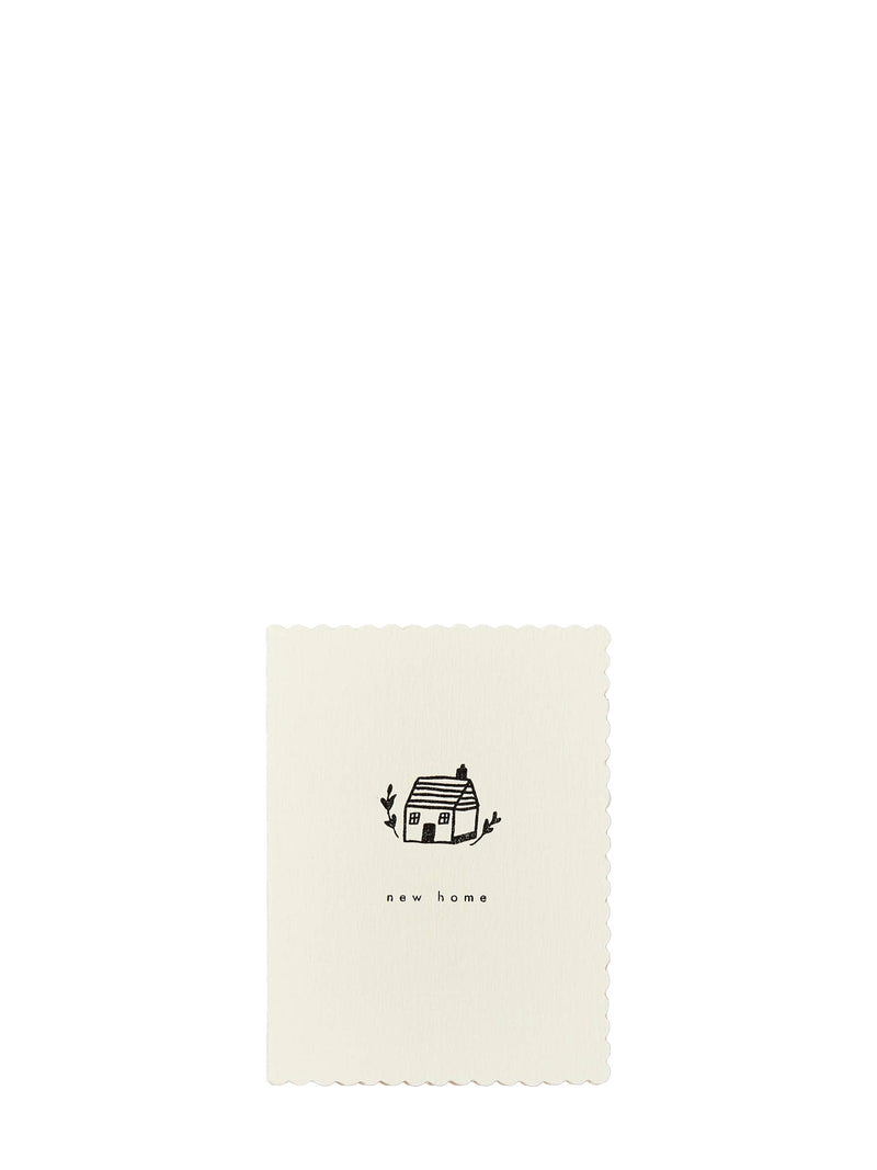 An off-white rectangular card with scalloped edges, featuring a small black line drawing of a house and the text 'new home' centered below it, set against a solid white background.