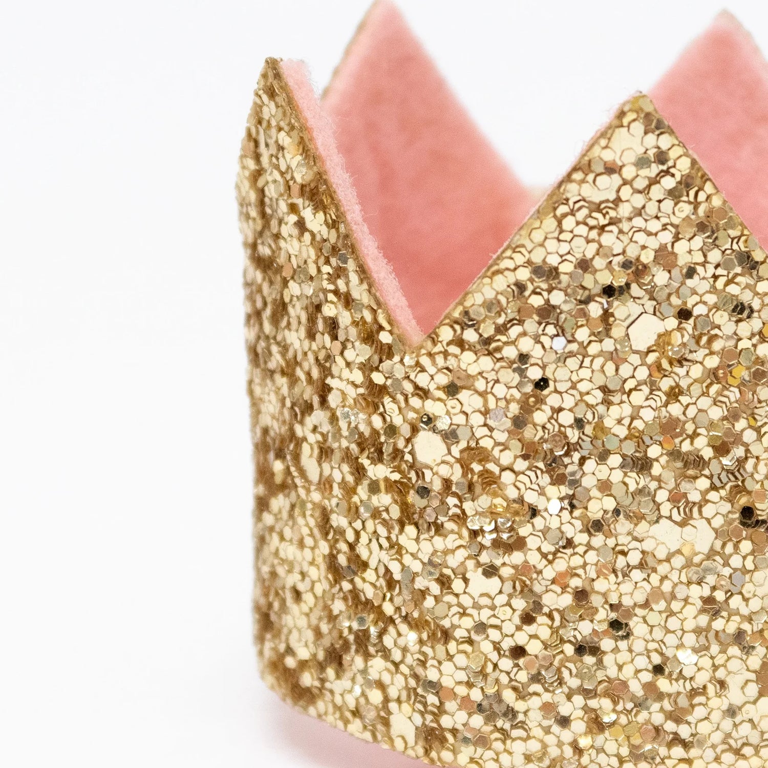 Gold glittery headband with pink interior on a white background