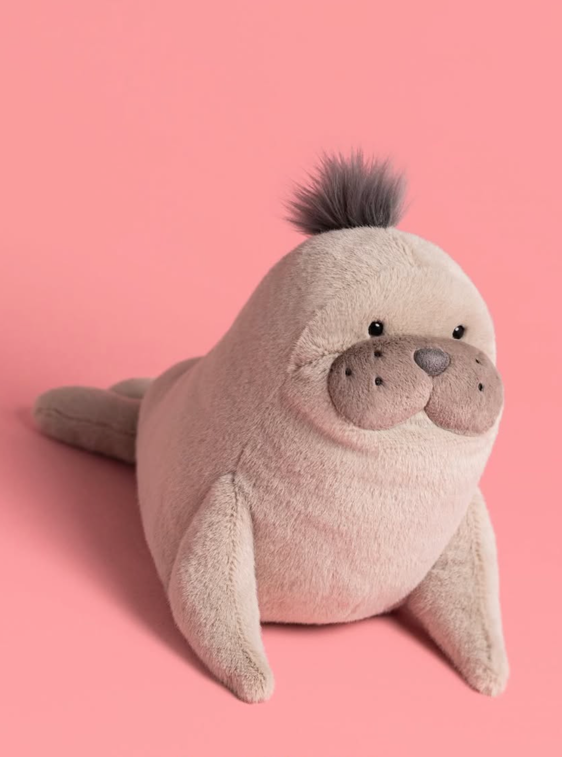 Plush seal toy on a pink background