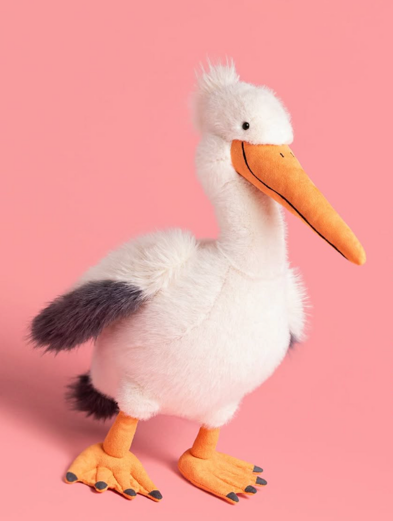 Plush pelican toy on a pink background