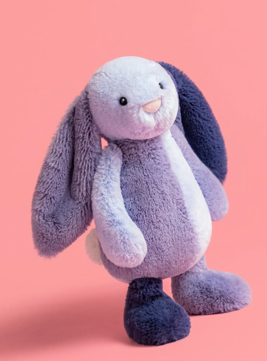 Plush bunny toy on a pink background