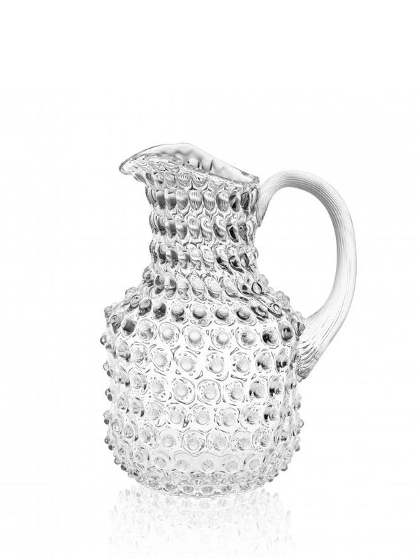 A clear glass square jug with a hobnail texture and a curved handle.