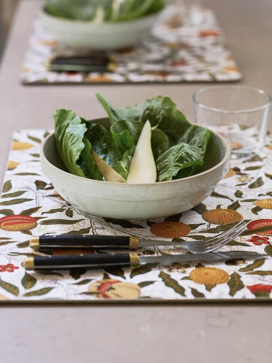 Bowl of salad on a decorative placemat with cutlery