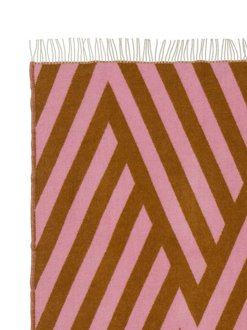 Fringed wool throw with pink and brown chevron pattern on a white background