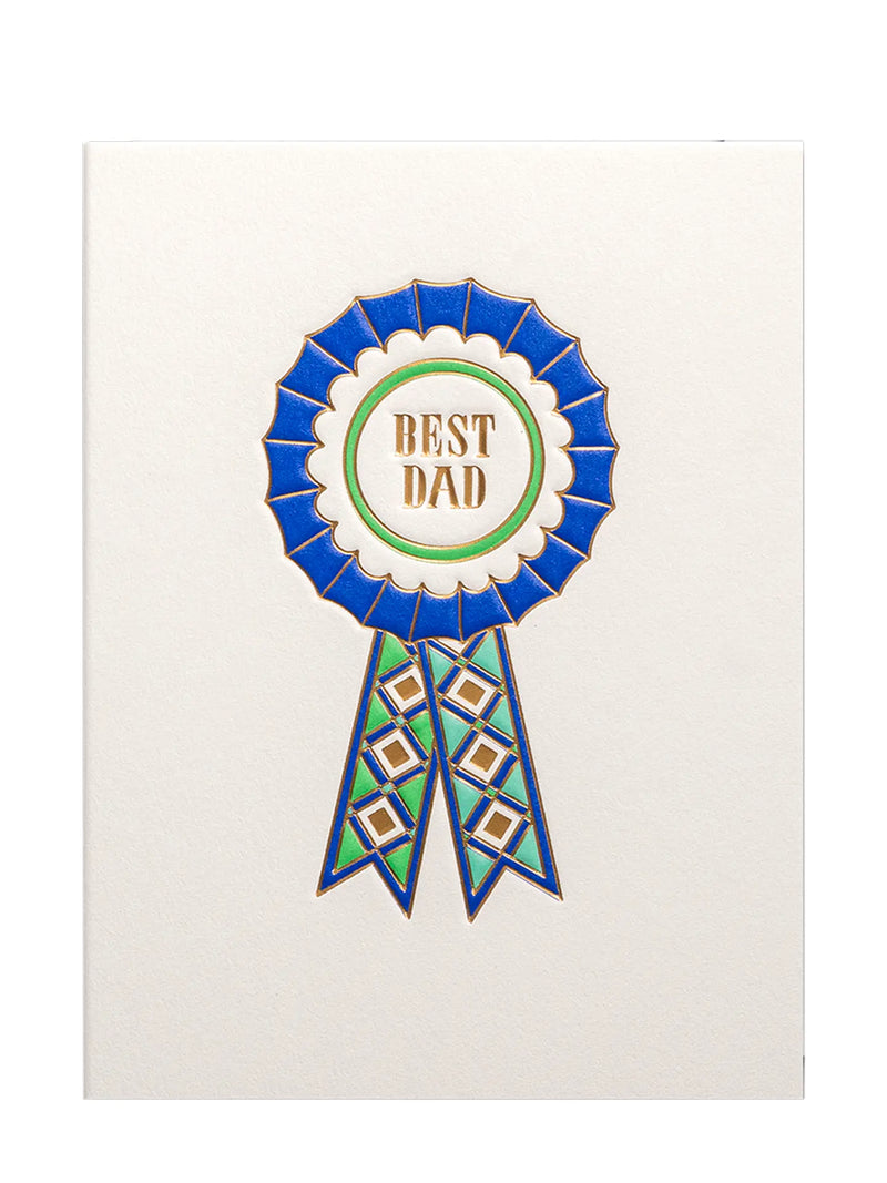 A square cream-colored greeting card featuring a large rosette award ribbon design with the words 'BEST DAD' in gold lettering on a white center, surrounded by blue and green details.