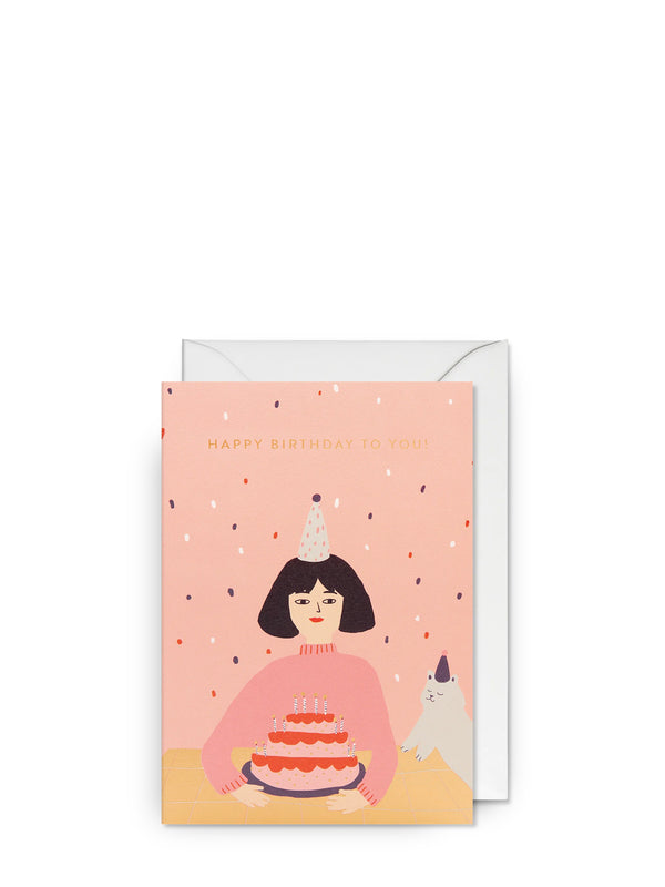 Birthday card with illustration of a person holding a cake and a dog, on a pink background.