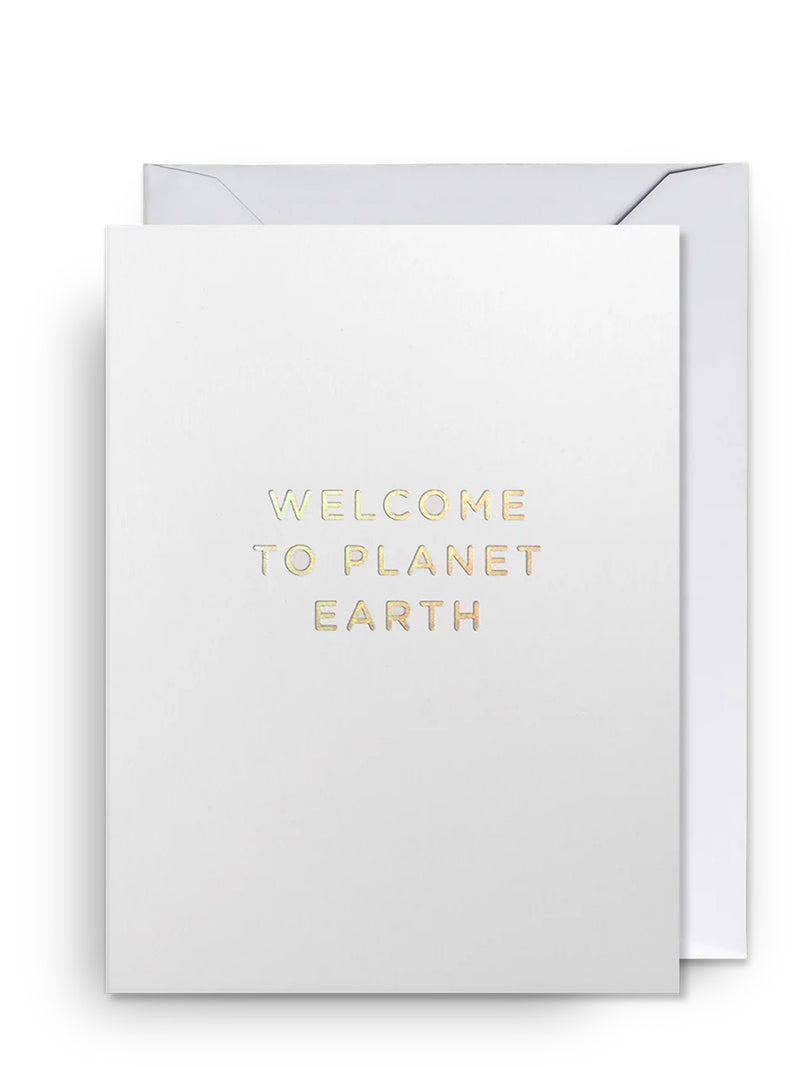 White new baby greeting card with 'Welcome to Planet Earth' text in gold and white envelope on a white background