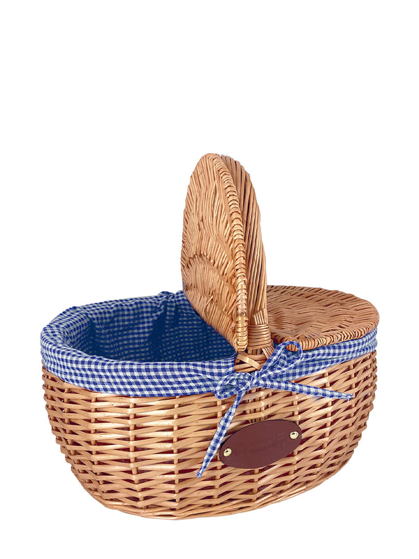 A traditional French wicker picnic basket with a blue checkered interior and an arched handle.