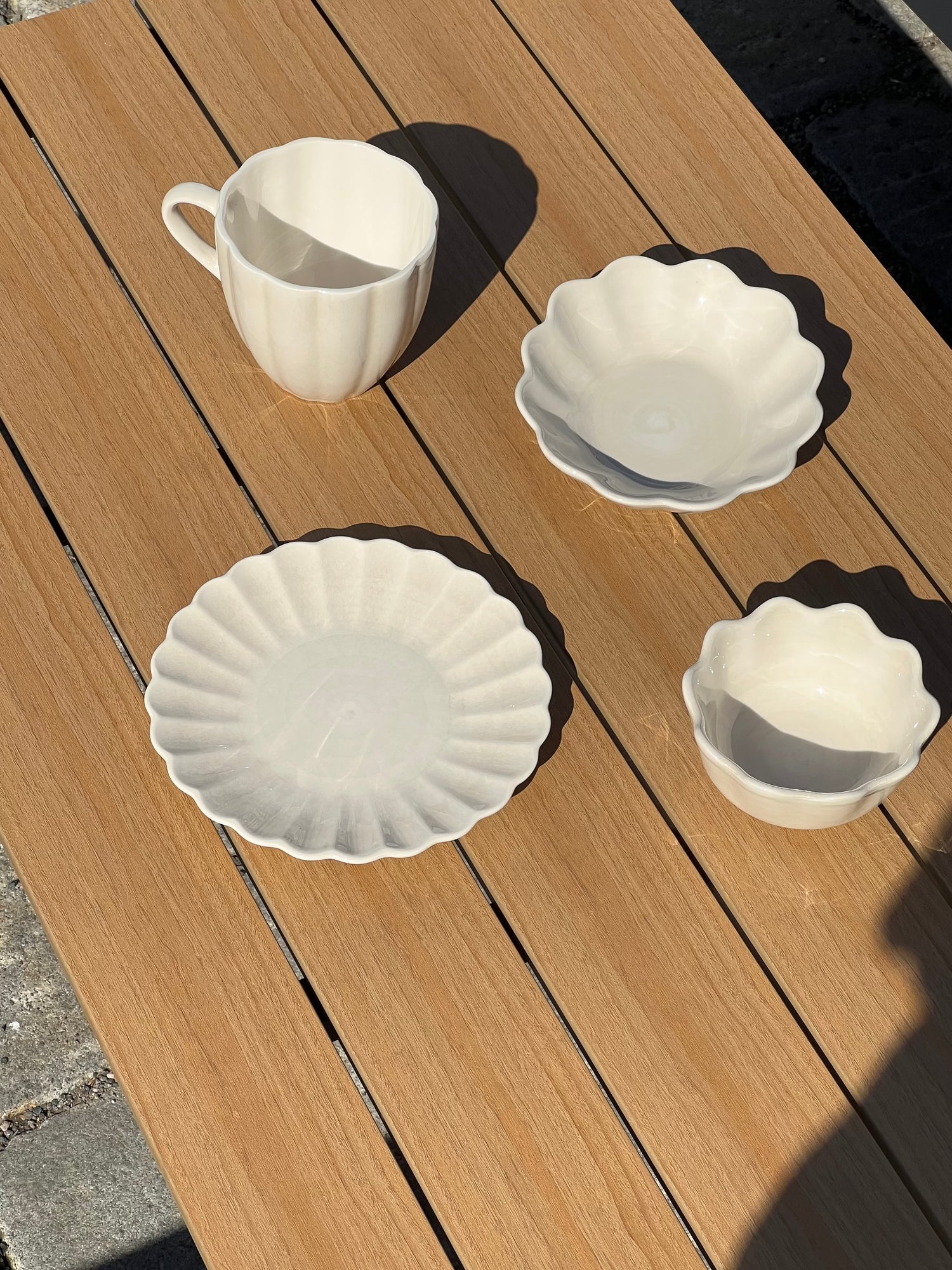 Set of white ceramic dishes on a wooden surface