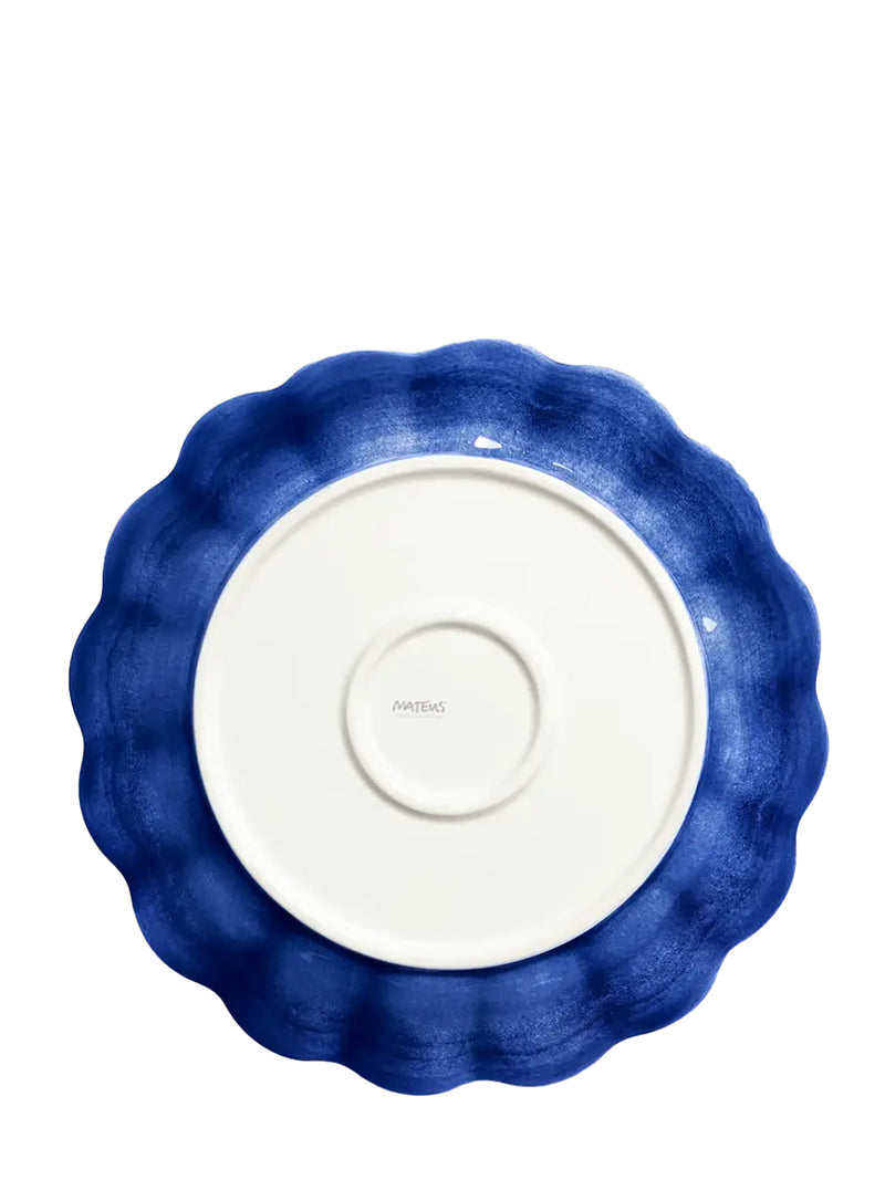 Blue ceramic dish with scalloped edge on a white background