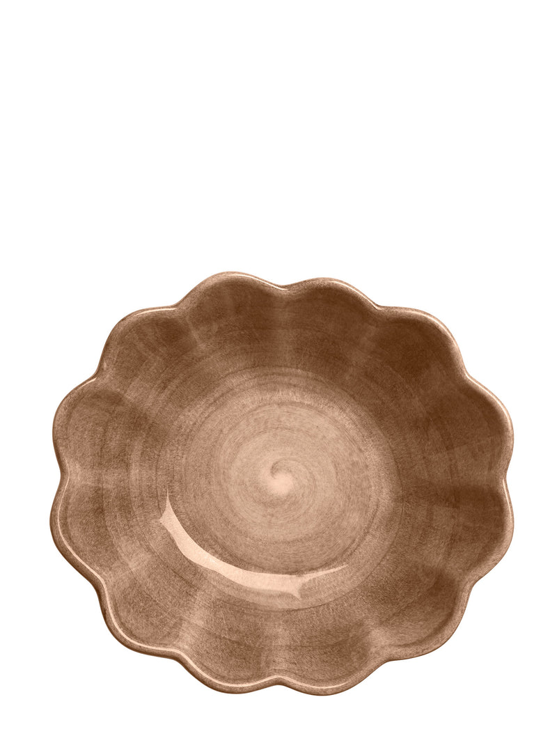 Brown ceramic bowl with scalloped edge on a white background