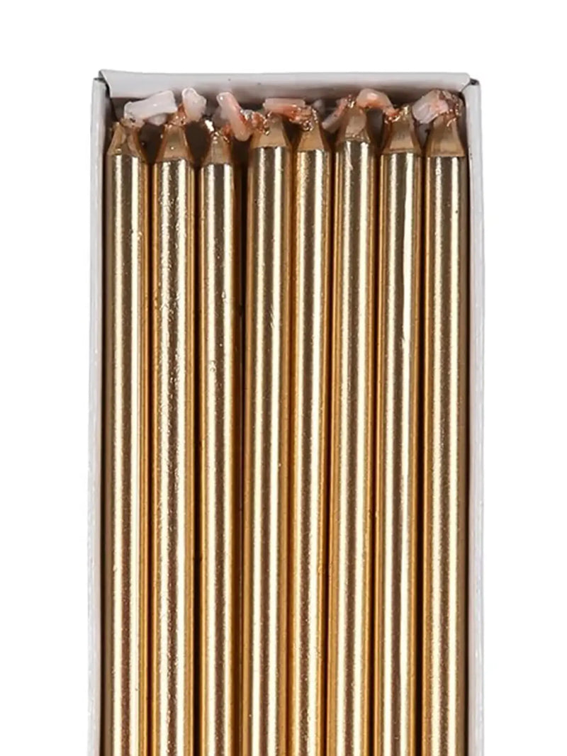 Close-up of thin golden candles.