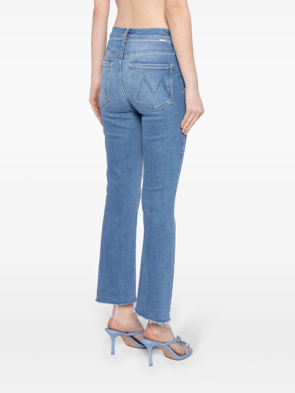 Person wearing light blue jeans on a white background
