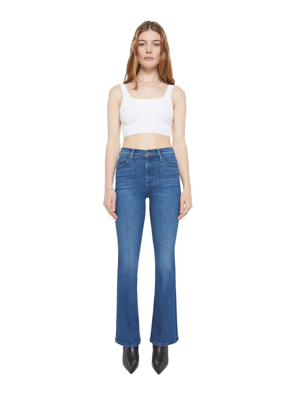 Woman wearing blue jeans and a white top on a white background