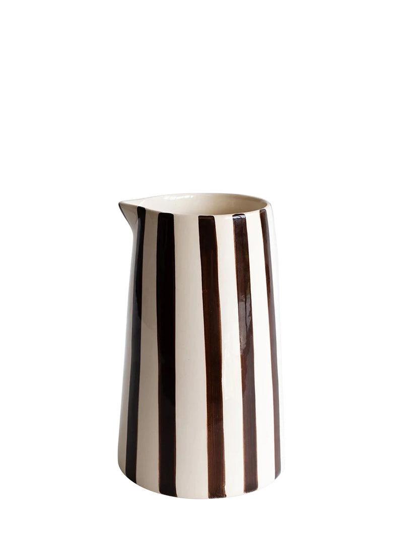 A glossy tall ceramic cylinder-shaped pitcher with vertical dark brown stripes on cream base, set against a plain white background.