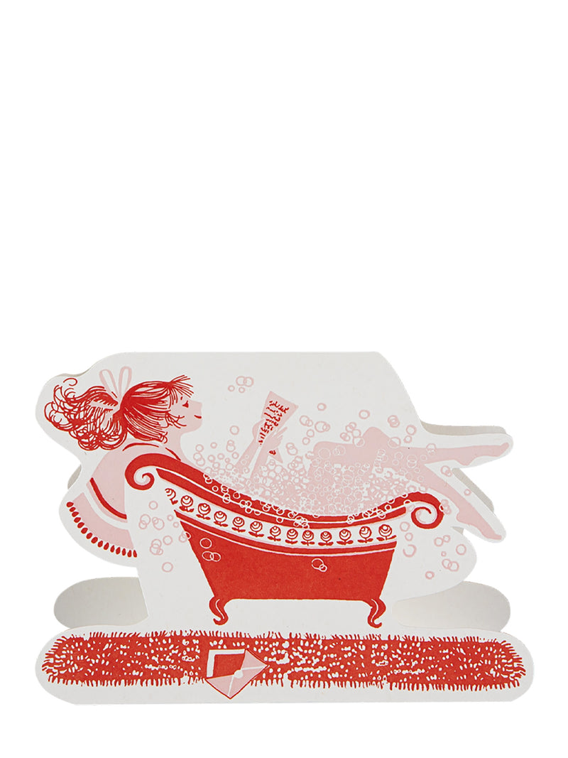 Decorative paper cutout with red bathtub and girl design on a white background