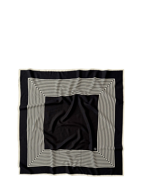 A square black scarf with a cream-colored border and concentric striped geometric pattern, laid flat on a white background.