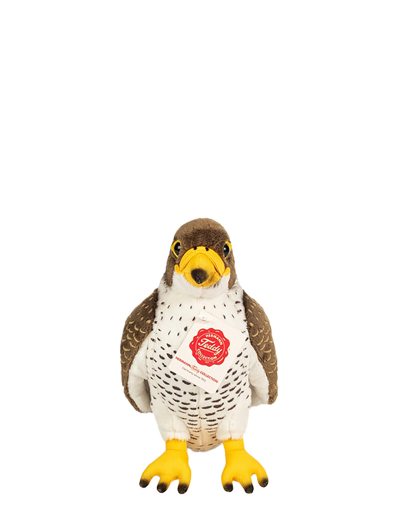 A stuffed bird toy shaped like a small falcon or penguin-like bird, with brown wings and head, a white body, yellow beak and feet, and a red circular chest patch. The toy is centered on a plain white background.