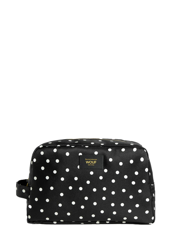 Black toiletry bag with white polka dots on a white background