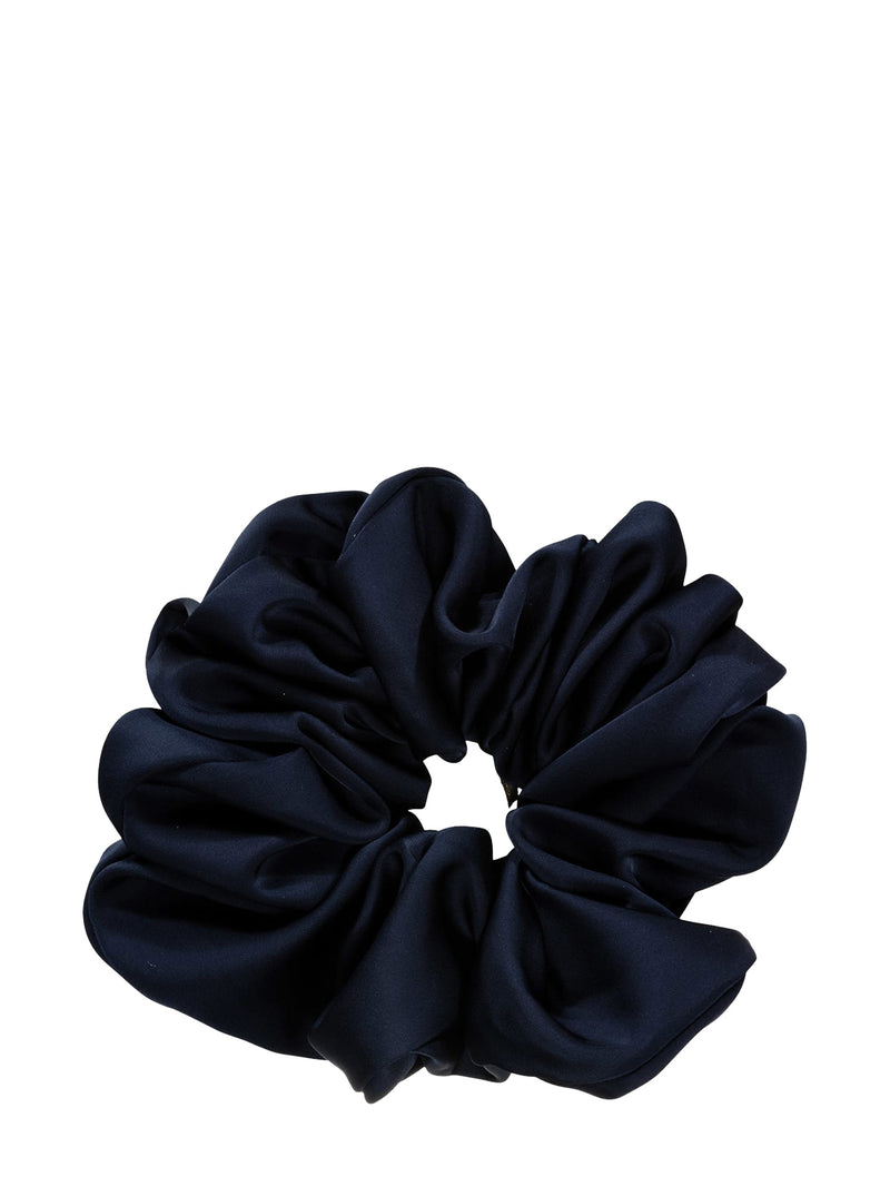 A dark deep navy blue satin scrunchie with a soft, draped texture, shown against a plain white background.