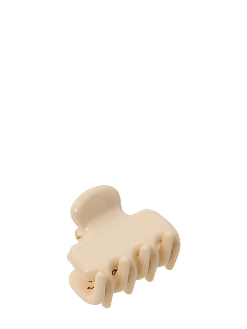 A cream-colored glossy hair claw clip on a solid white background.