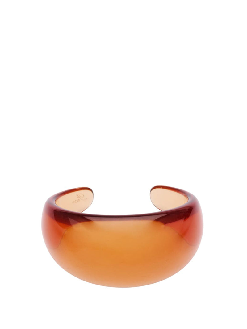 Amber orange coloured bangle or wrist cuff made of see through resin pictured on a white background