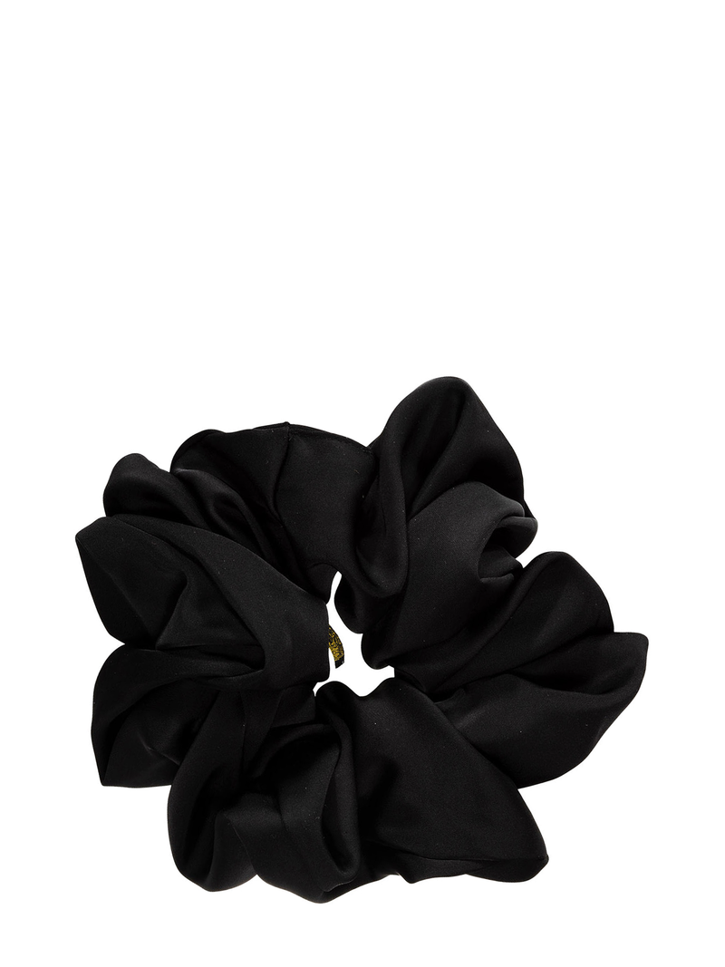 Shiny scrunchie from black satin fabric against plain white backround