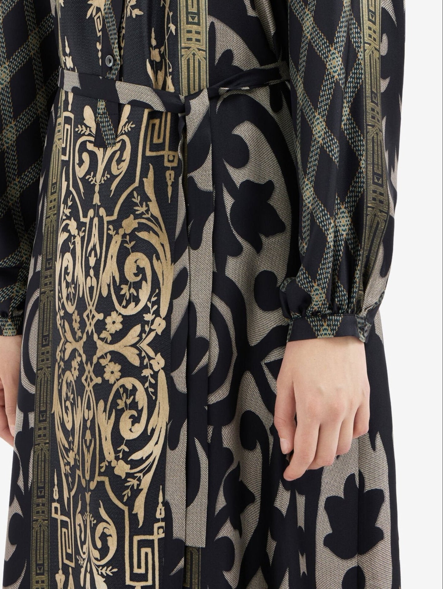 Patterned dress with gold and black design on a white background