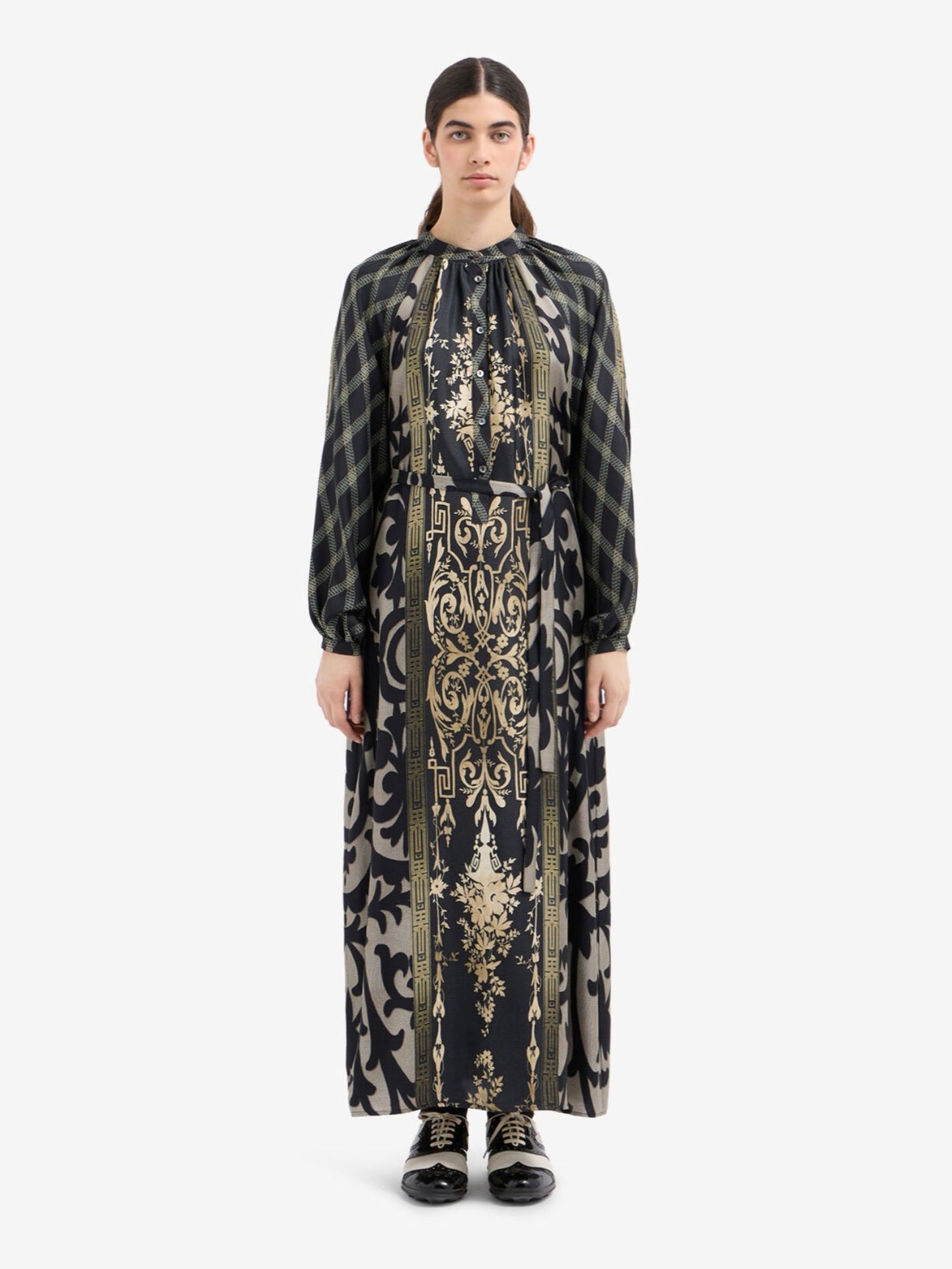 Woman wearing a long, patterned dress on a white background