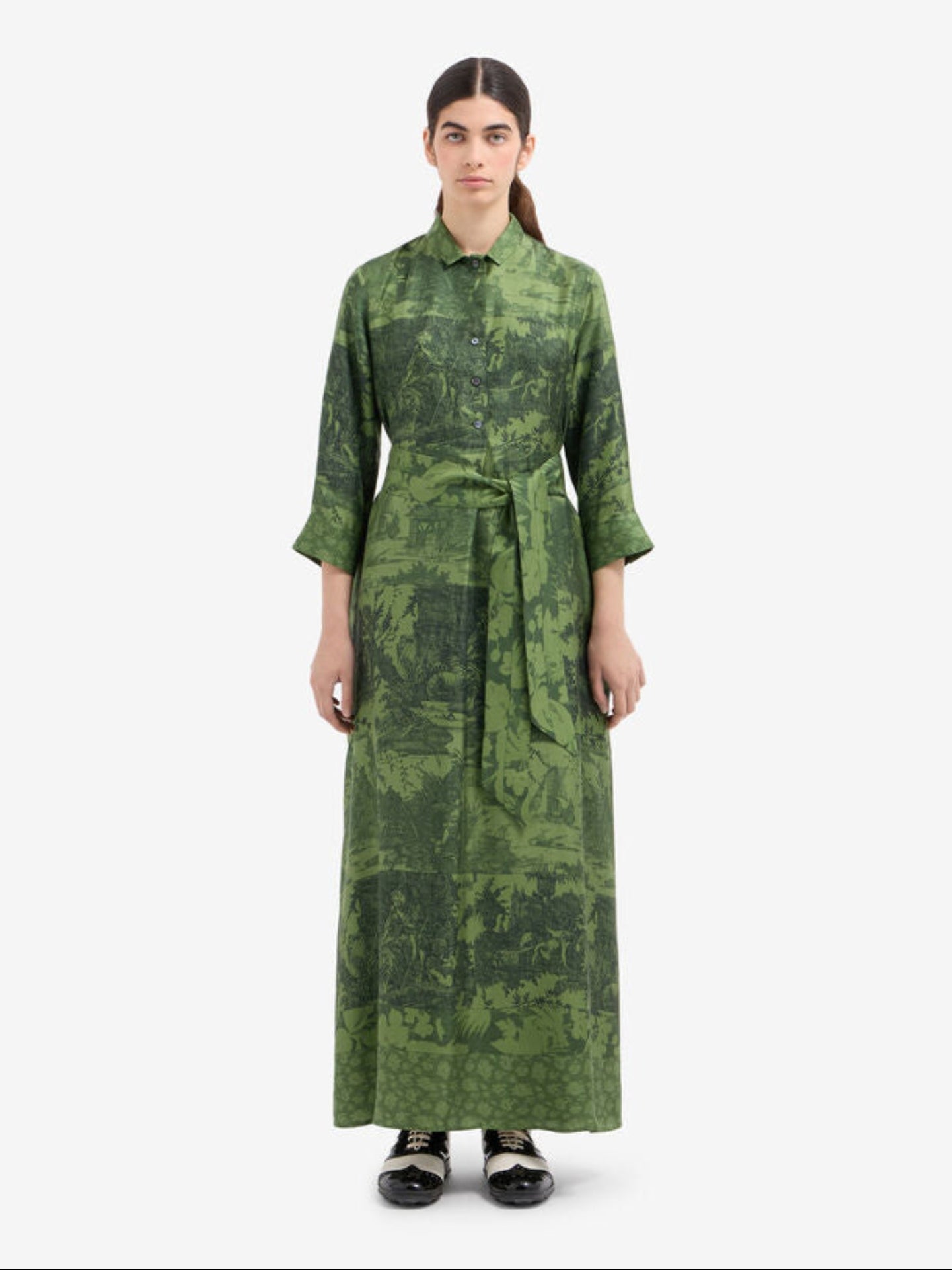 Woman wearing a green patterned dress on a white background