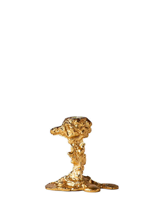 A gold-plated aluminum drip candle holder has an abstract, fluid-like shape on a white background.