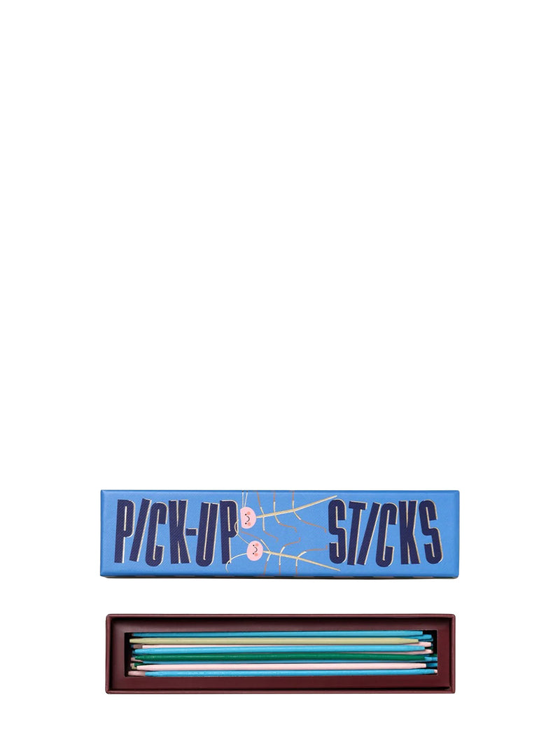 A boxed set of pick-up sticks game shown on a plain white background, with the blue lid labeled 'PICK-UP STICKS' above an open dark tray containing multiple colored sticks.