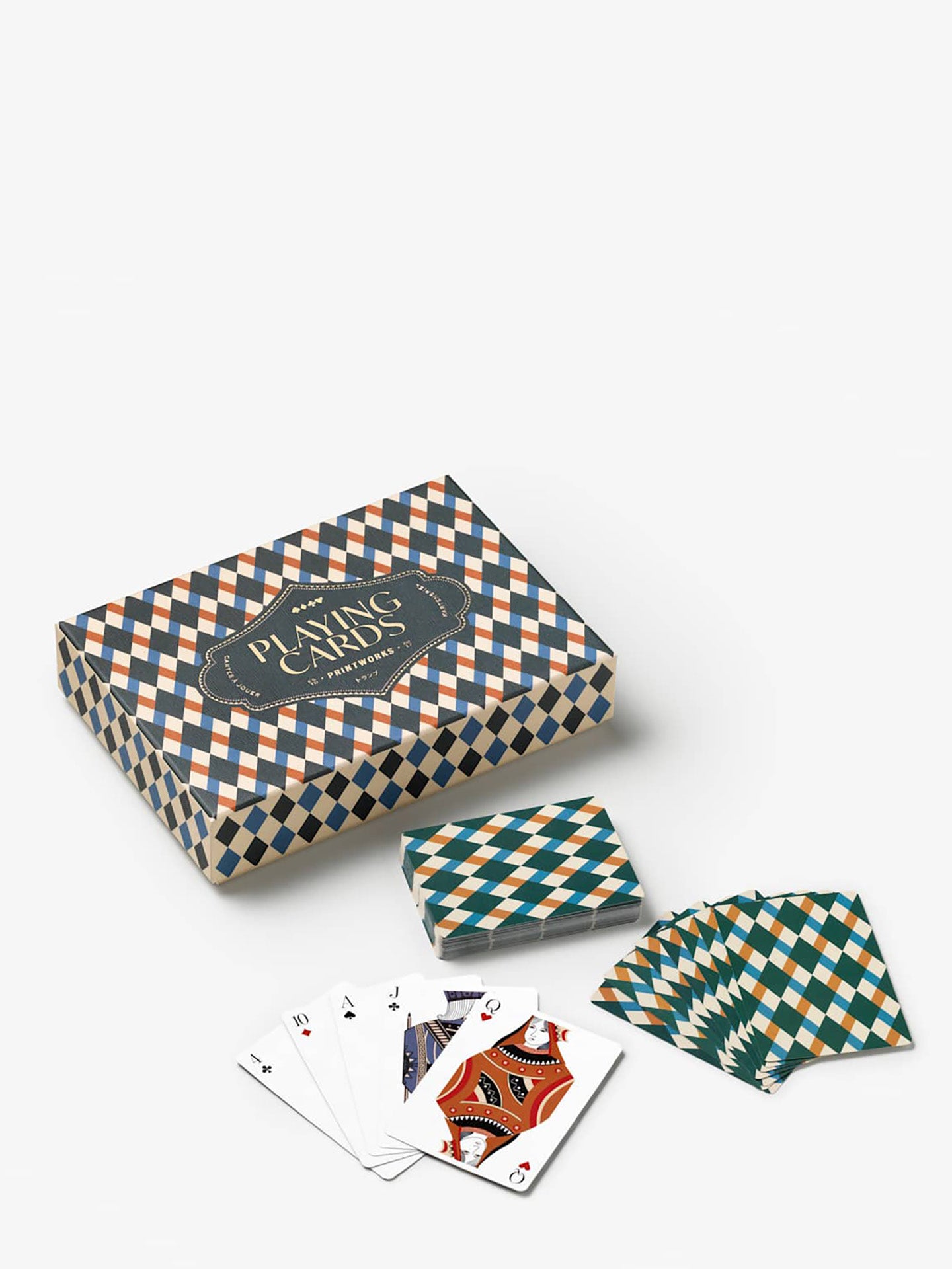 A boxed deck of patterned playing cards with several cards fanned out in front, shown on a clean light gray studio background. The box and card backs feature a repeating diamond/check pattern in teal, cream, and orange, with a dark central label reading 'Printworks', and at the lowest are 5 cards open in a fan shape with elegantly illustrated queen of hearts in ochre and equally stylish jack of clubs visible in blue and teal.