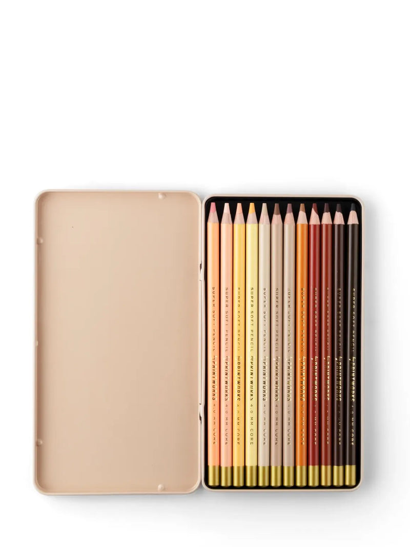 A set of 12 brown, beige, beige, yellow and peach tone wood colour pencils displayed in a open metal tin case.