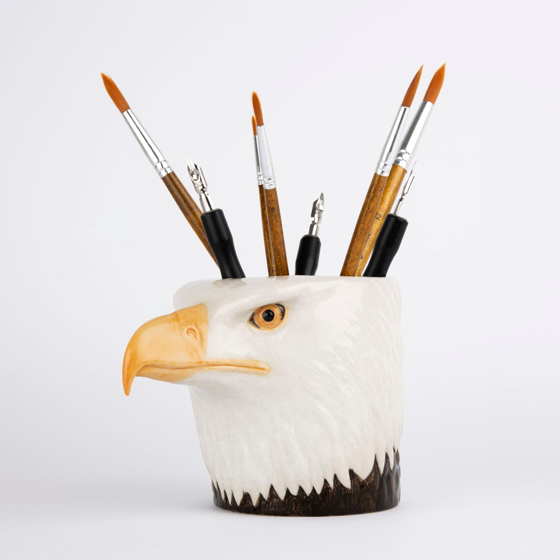 Eagle-shaped pen holder with paintbrushes on a white background