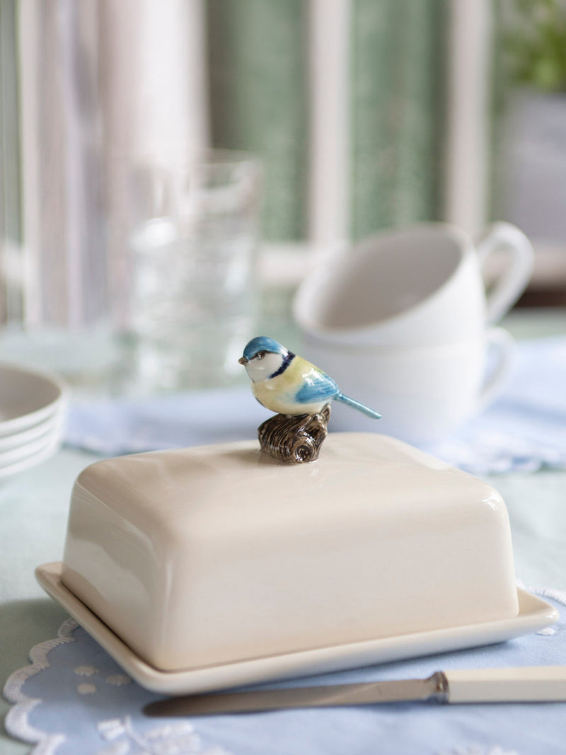 Blue ceramic bird sitting on butter dish 