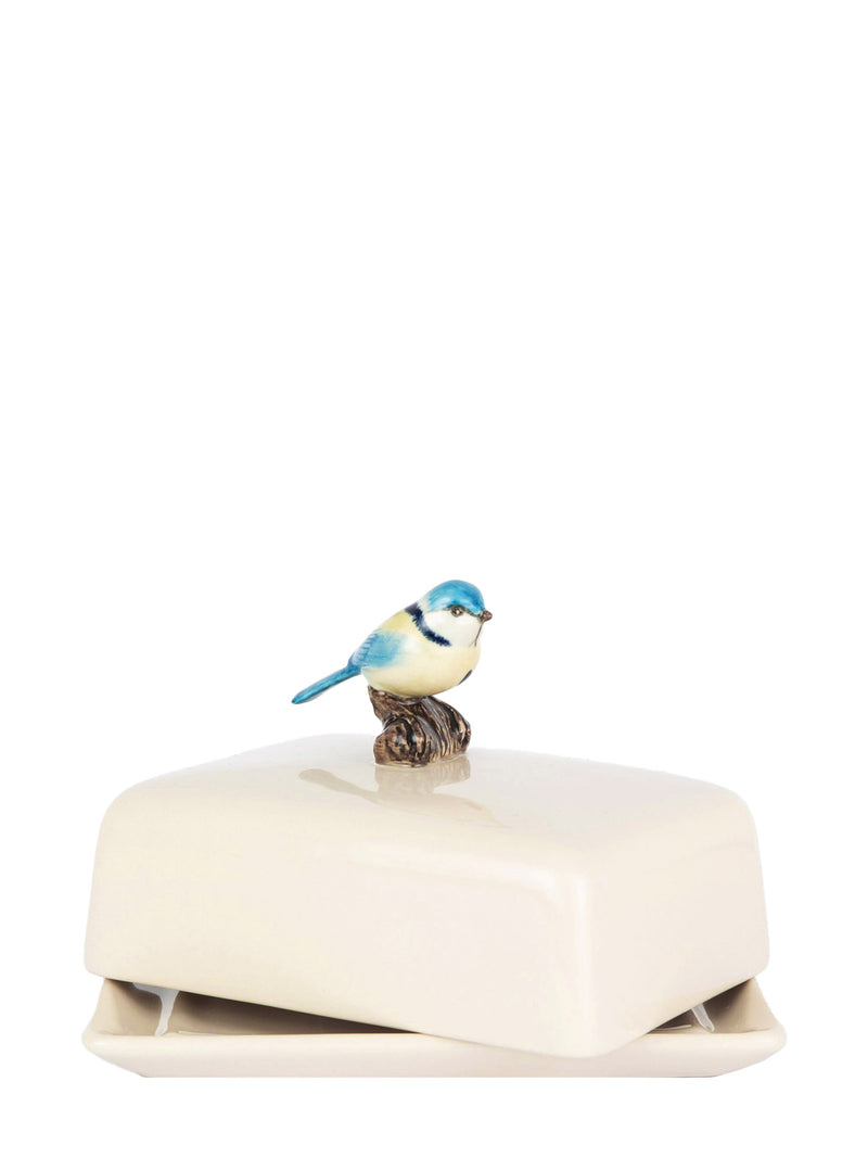 Decorative bird figurine on a white ceramic box 