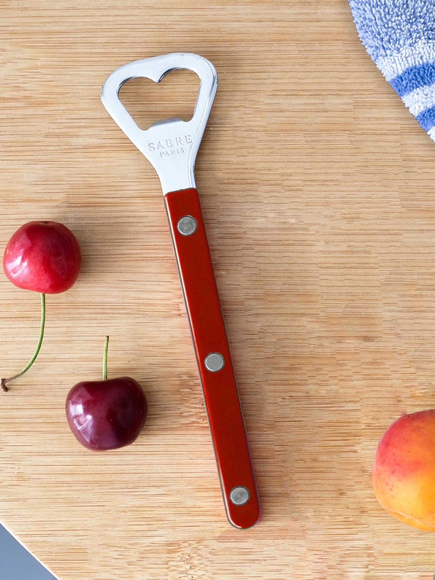 Red bottle opener on the wooden table