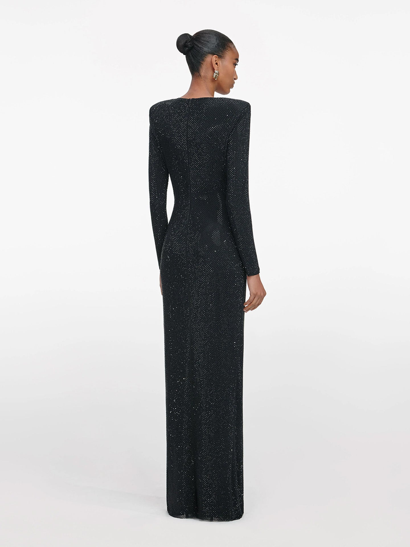 Woman wearing a black long-sleeve evening gown on a white background