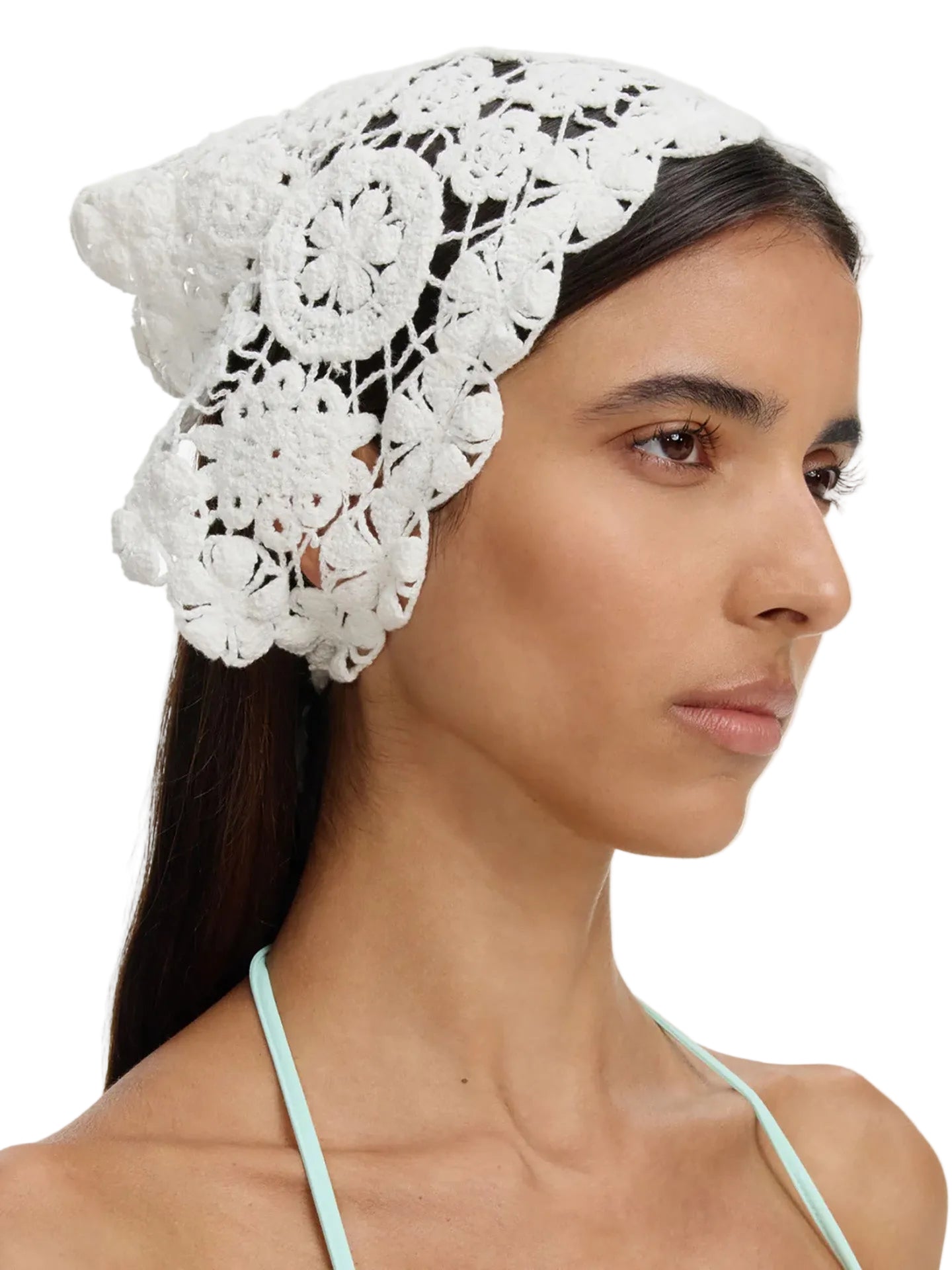 Woman wearing a white lace headscarf on a plain background