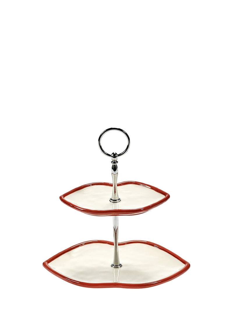 Two-tiered ceramic serving trayin shape of lips with red rim and ivory base, put together with silver stand on a white background