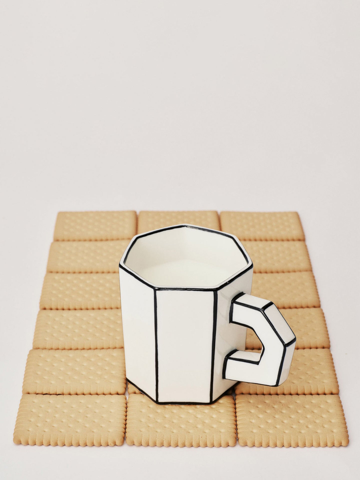 Geometric white mug on a textured beige surface
