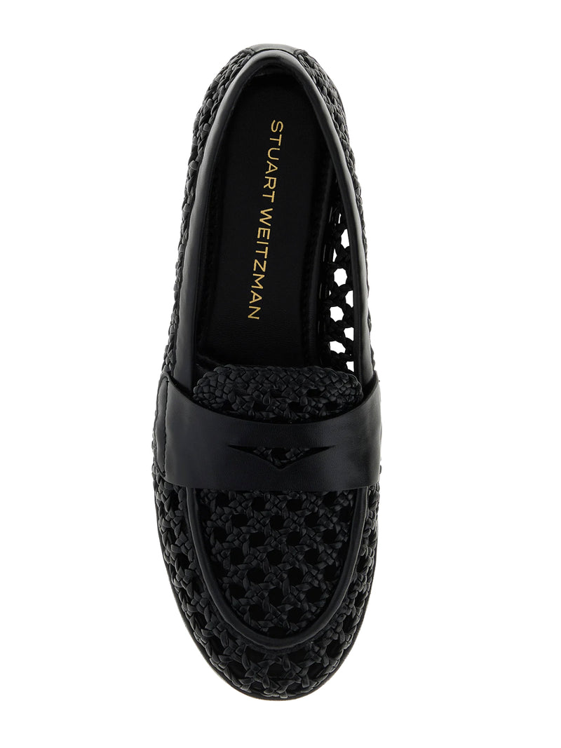 Black loafer shoe with perforated design on a white background