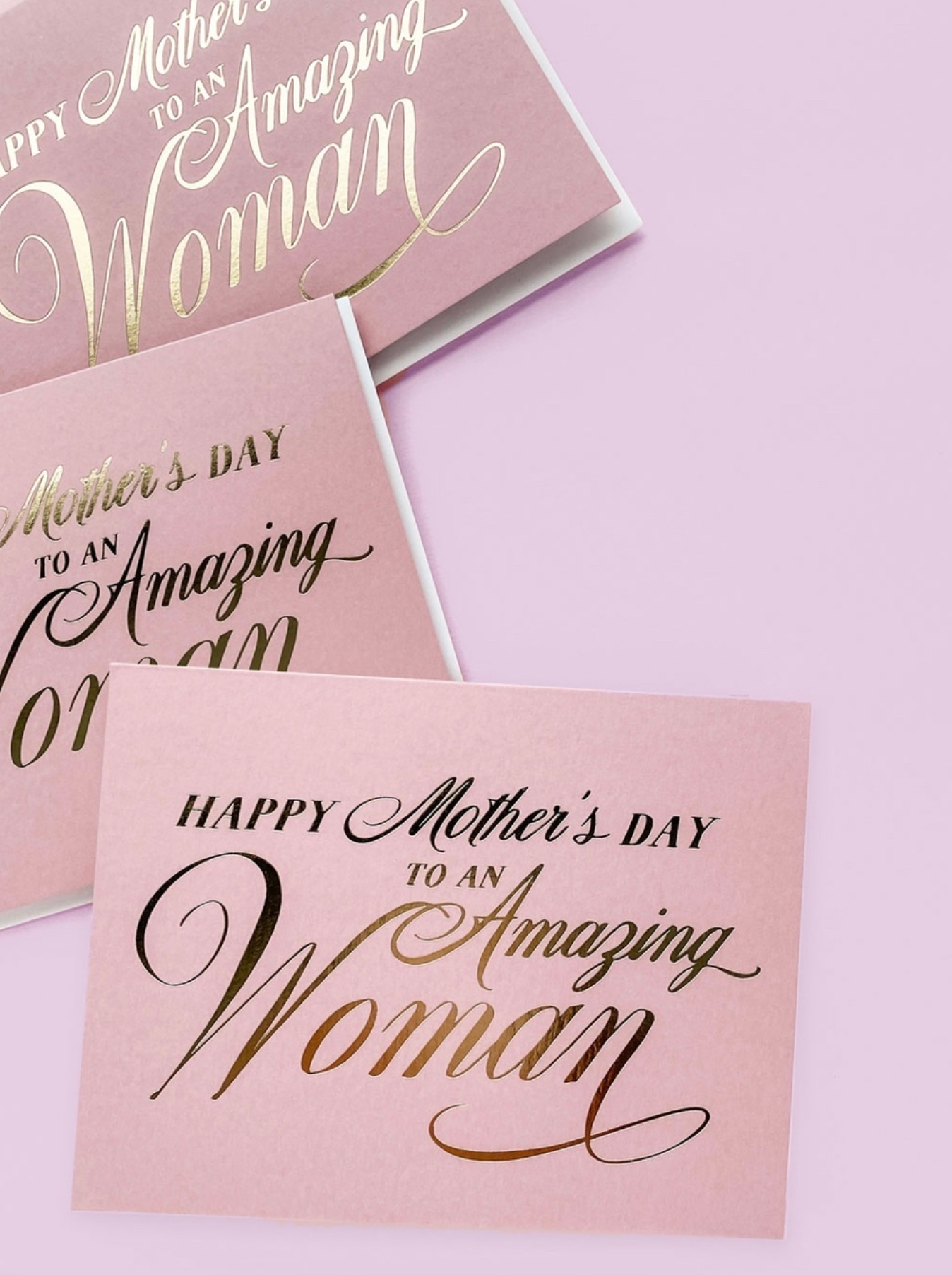 Three 'Happy Mother's Day to an Amazing Woman' cards on a light pink background