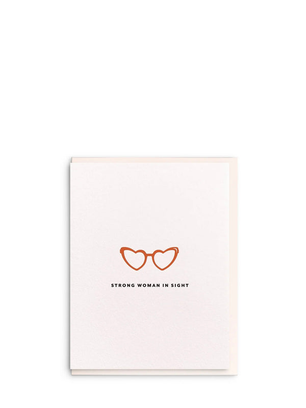Card with heart-shaped glasses design and text 'Strong woman in sight' on a white background