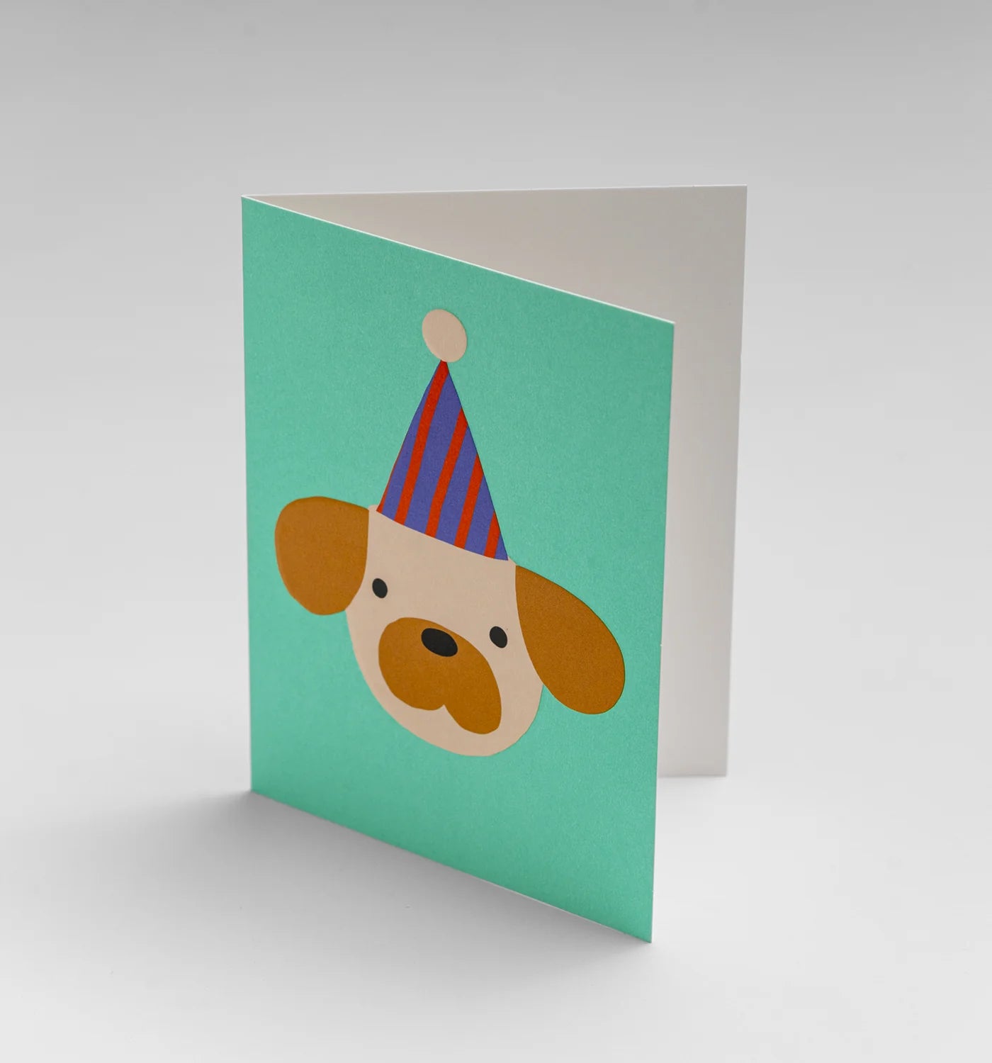 Greeting card with a dog wearing a party hat on a green background